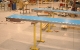 Low profile sanitary belt conveyor on slider bed frame